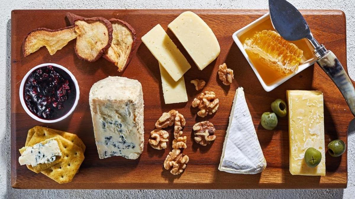On this board, clockwise from top left: dried pears, havarti, honey with honeycomb, English cheddar, olives, Camembert, walnuts, Castello Creamy Blue, crackers and currant jam. MUST CREDIT: Photo by Stacy Zarin Goldberg for The Washington Post.