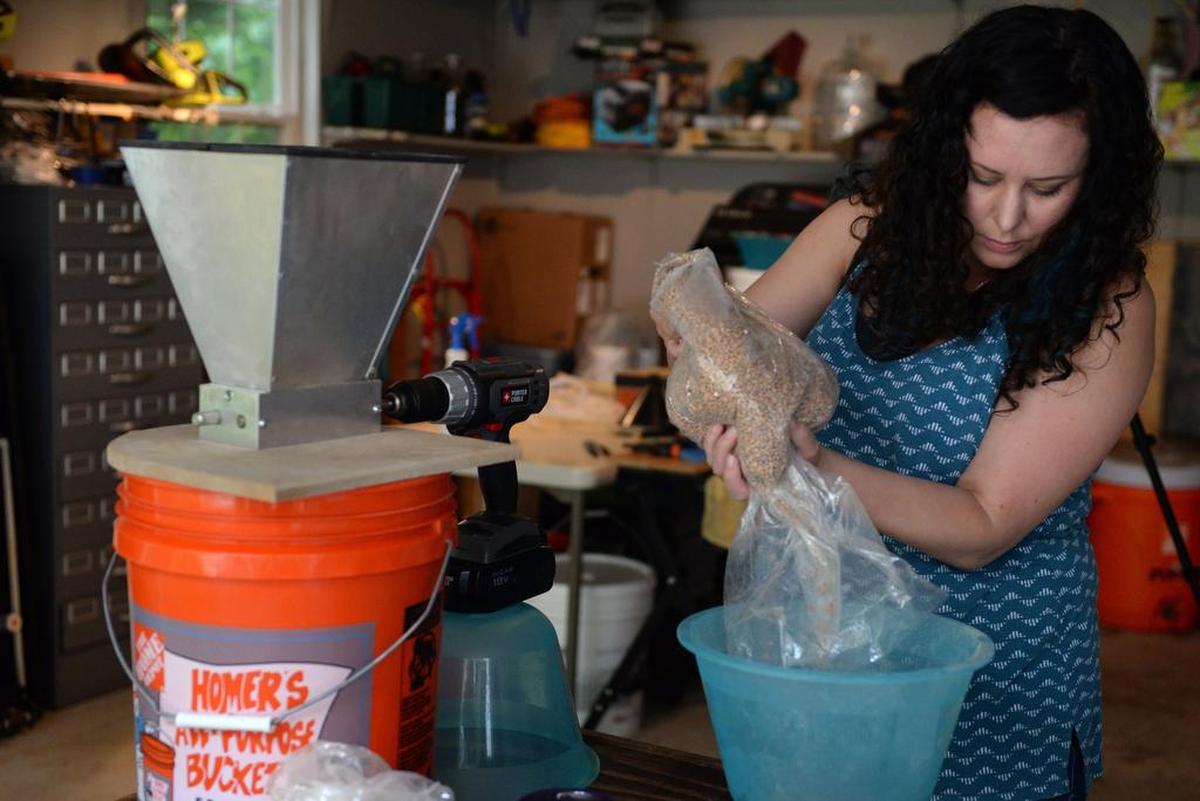 Blair pours grain into a bowl to weigh before grinding it.