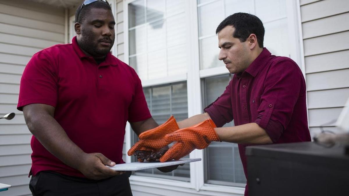 
Charlotte Symphony member Andrew Fierova unloads barbecue ribs from his smoker with help of friend Gerald Ligons on Sunday, July 26, 2015. 
