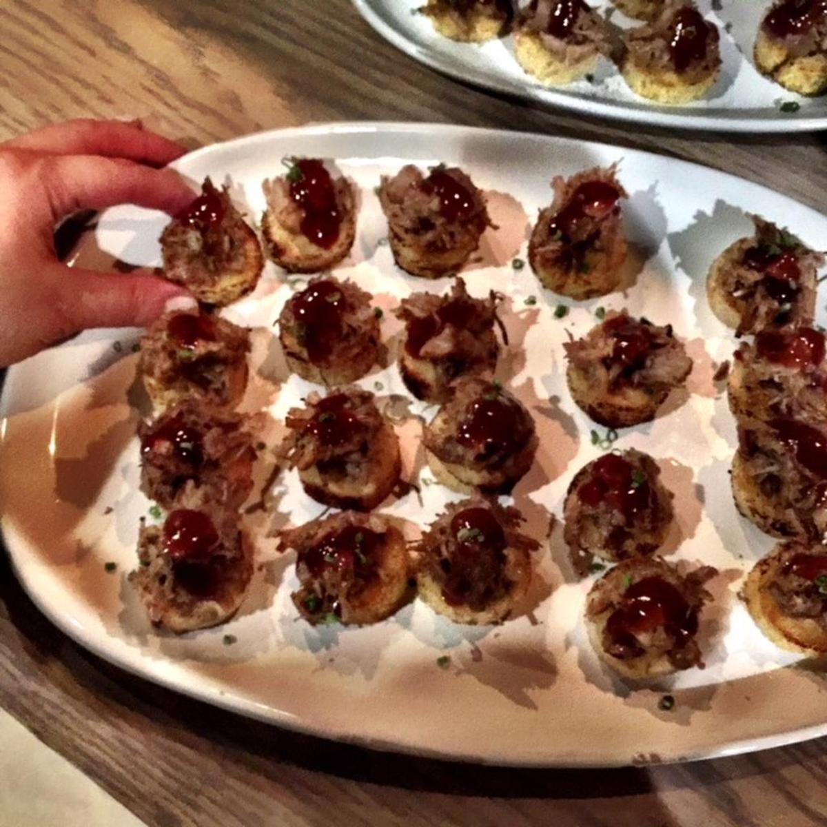 Fried green tomatoes topped with pork barbecue and preserved lemon.