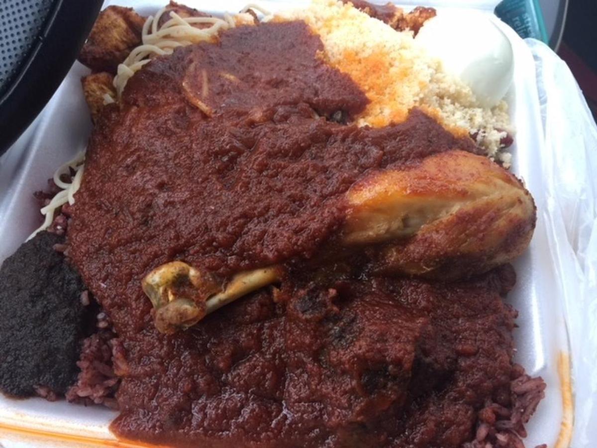 The fried drumstick at Mama Gee’s is on top of waakye, a pile of red rice and beans, spaghetti, a hard-boiled egg, chewy plantains, shiso pepper paste and a big pool of thick tomato stew.