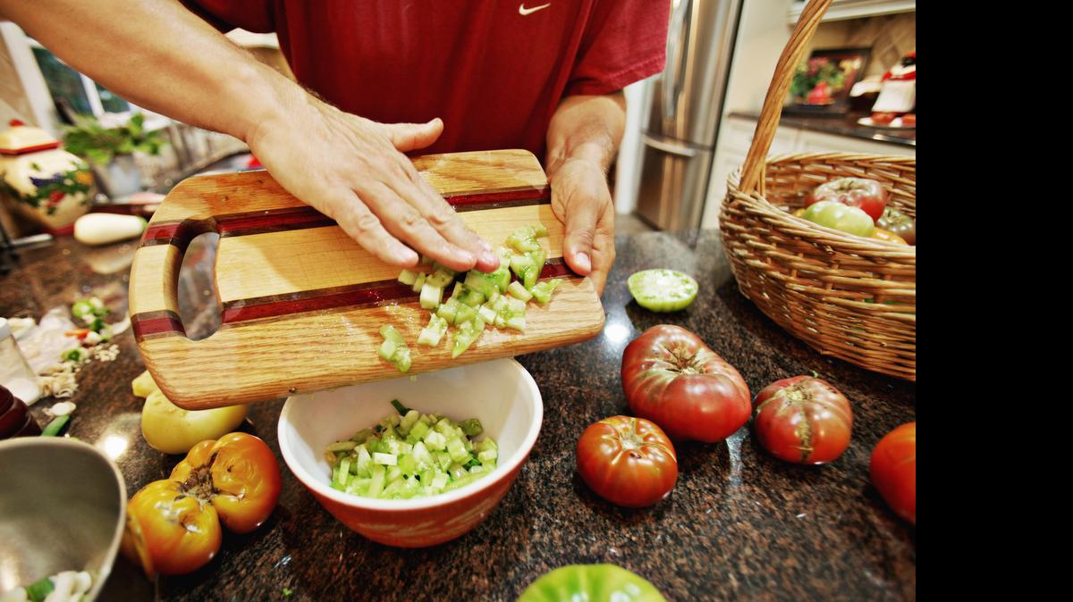 
Craig LeHoullier adds fresh tomatoes from his garden to make a fresh mild salsa at his North Raleigh home on Thursday, July 23, 2015.
