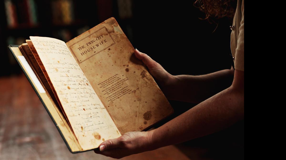 
Alison Barnett, Business Services Coordinator for the North Carolina Collection, holds the cookbook, "The Young Housewife's Counsellor and Friend," dating back to 1875 which inspired her to curate an exhibit of 900 cookbooks at UNC'S Wilson Library. The cookbook is the oldest included in the exhibit, " From Brunswick Stew to Barbecue: The Cookbook as Cultural History" which is on view from opens June 18 and will be on view through October 4. 
