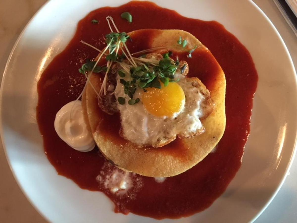 Rancherito is a stack of crisp tortillas layers with poblano cream, chunky mashed lentils and a fried quail egg.
