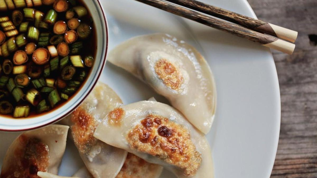 These Pork and Shiitake Mushroom Pot Stickers are served with a spicy soy sauce topped with green onions.