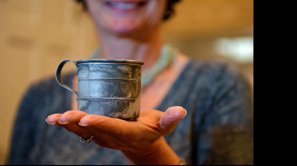 Kim Love Stump and a tin measuring cup she has from her mother.