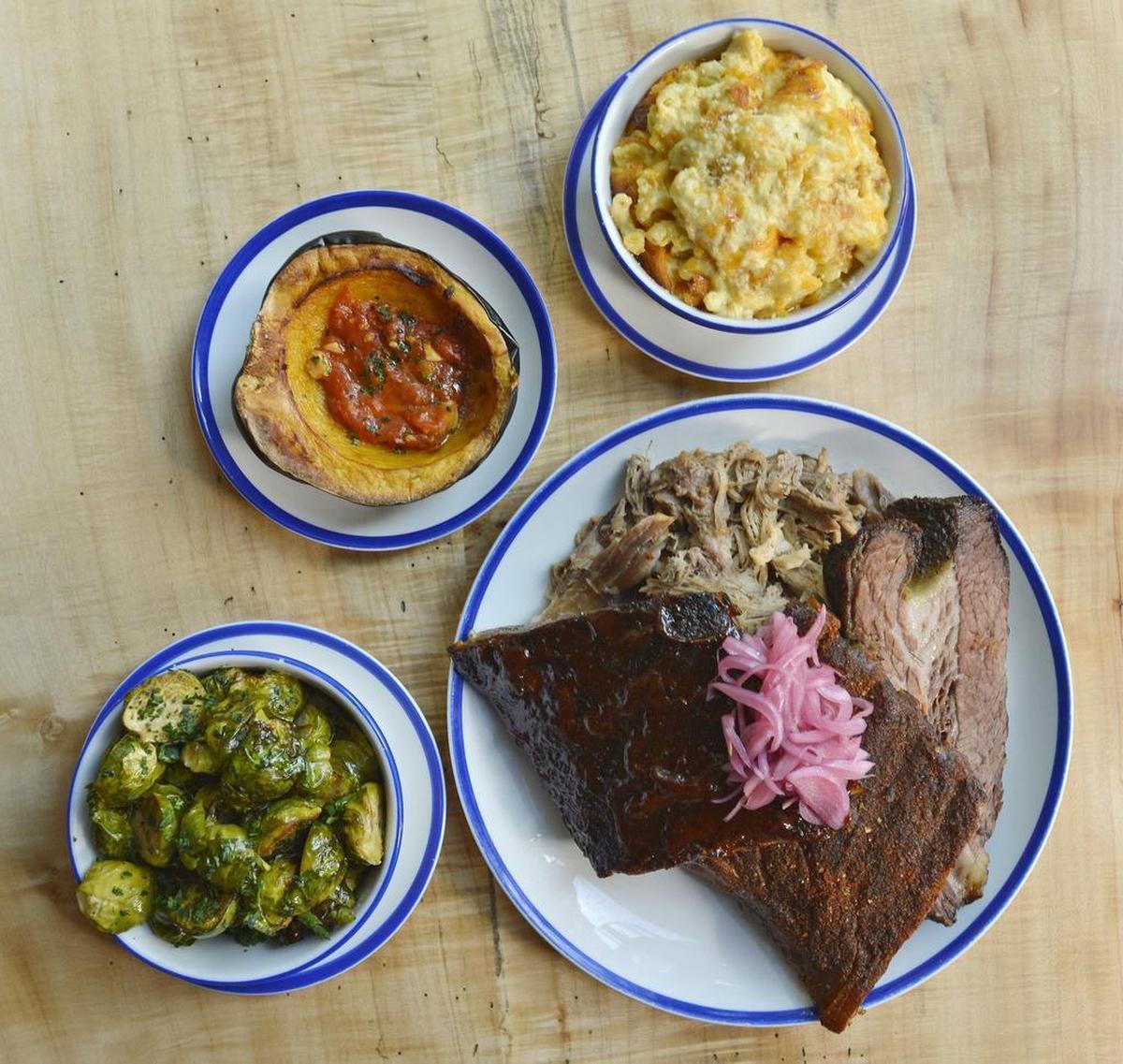 The Cue Combo tray at City Smoke: Brisket, pulled pork, Kansas City and Texas ribs, with sides of rotisserie Brussels sprouts, roasted acorn squash and mac & cheese.