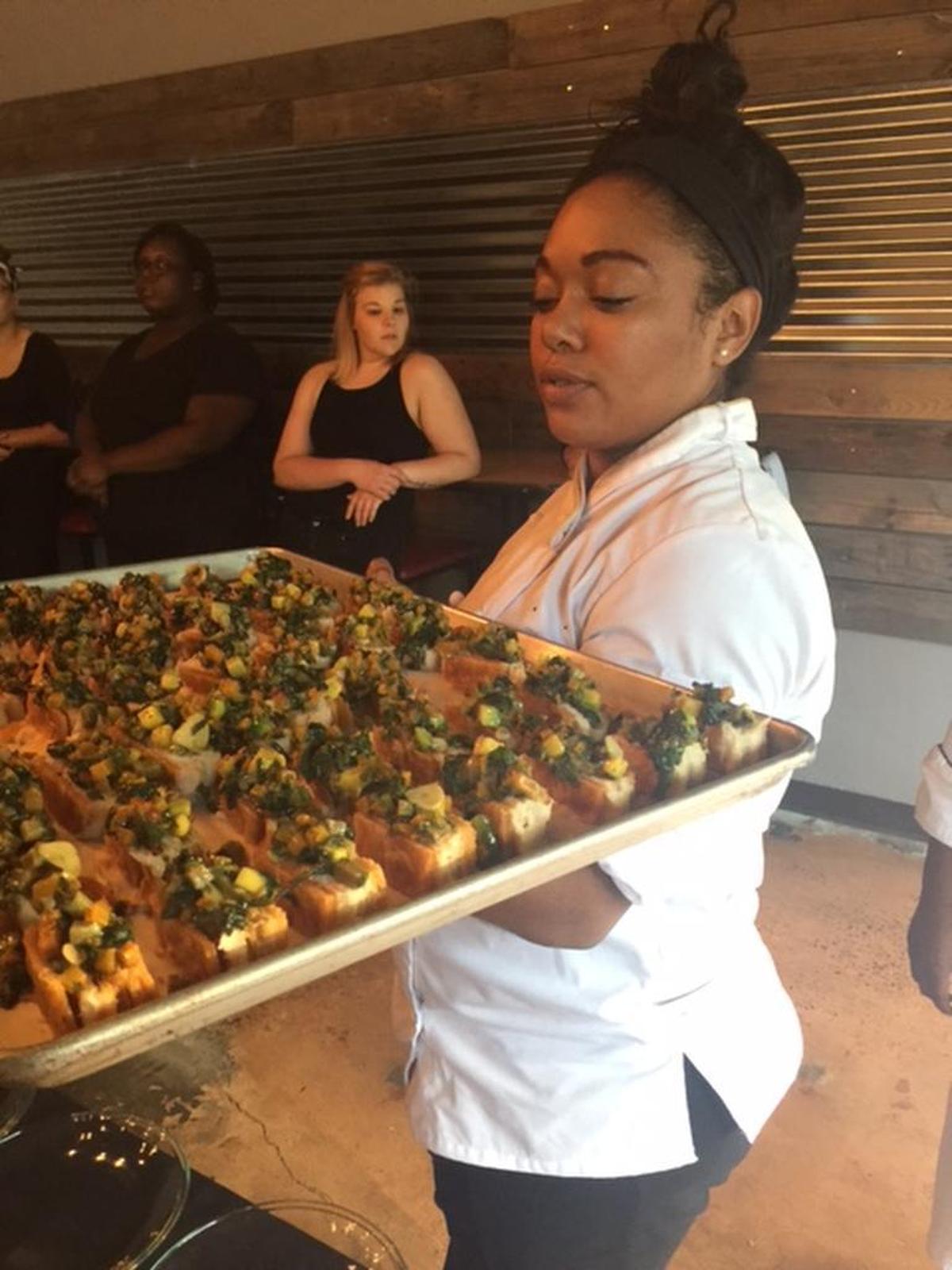 Elena Lundy, a culinary teaching assistant at Johnson & Wales, helps to plate Gregory Collier’s salt cod napoleon, the first dish at last week’s Caribbean-themed dinner.