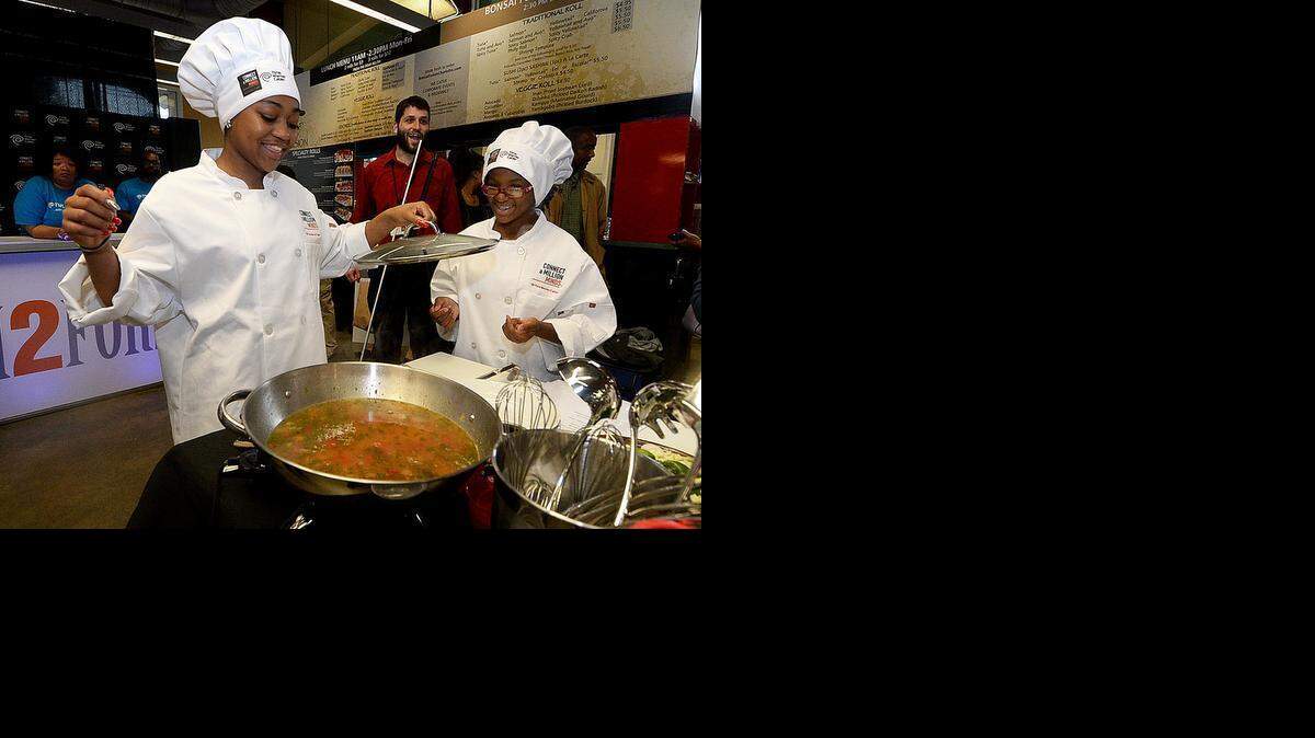 
Shayquana McGill, left, and De'Asia Jones, 13, right, of Whitewater Middle School check on the progress of their Mexican Stone Soup at STEM 2 Fork, a culinary competition at 7th Street Public Market on Friday March 27, 2015. The event featured students from four middle schools exploring the Science of Soup and the Math of Pizza, making soups and pizza which were judged by several local chefs. Whitewater Middle won the competition with their Mexican Stone Soup and White Pizza. 
