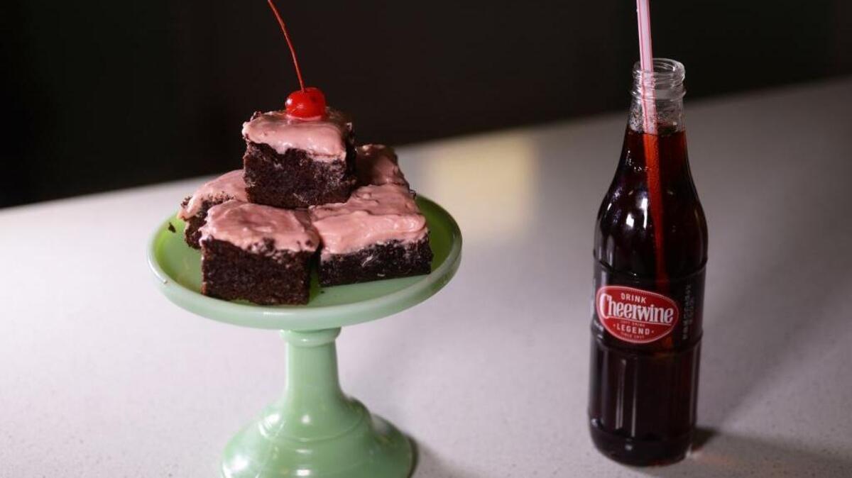 Cheerwine brownies are topped with a soft and sweet pink frosting.