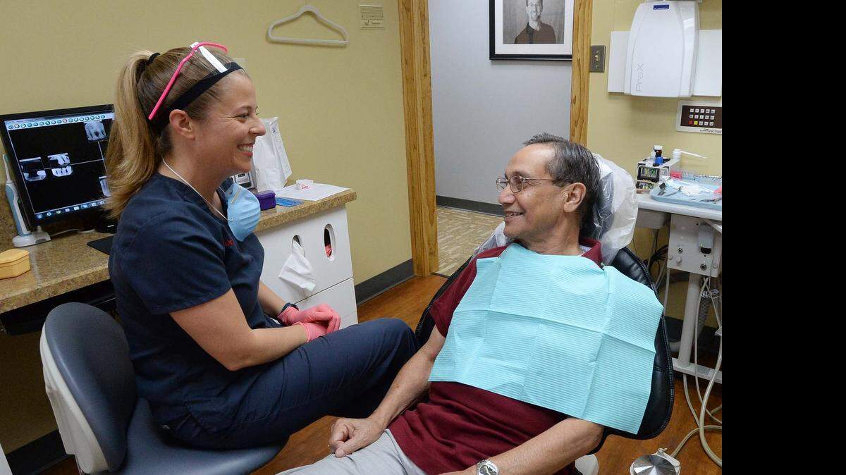 
Dr. Tricia Rodney finishes fitting a partial denture for Hanmanth Nippani, who receives free care through Physicians Reach Out.
