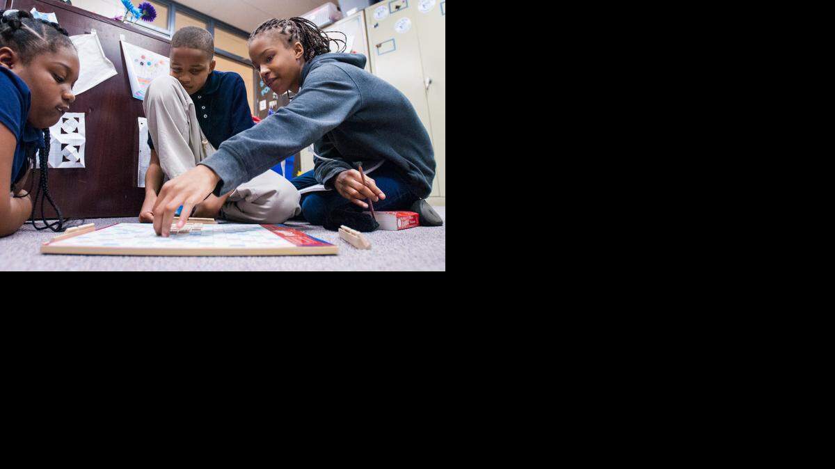 
Ida Christian, right, from McClintock Middle School, is helping the kids at Rama Road Elementary expand their vocabulary with Scrabble. Jaliya Kelly, 9, left, and Tywaun Jenkins, 10, wait to put down their words. 
