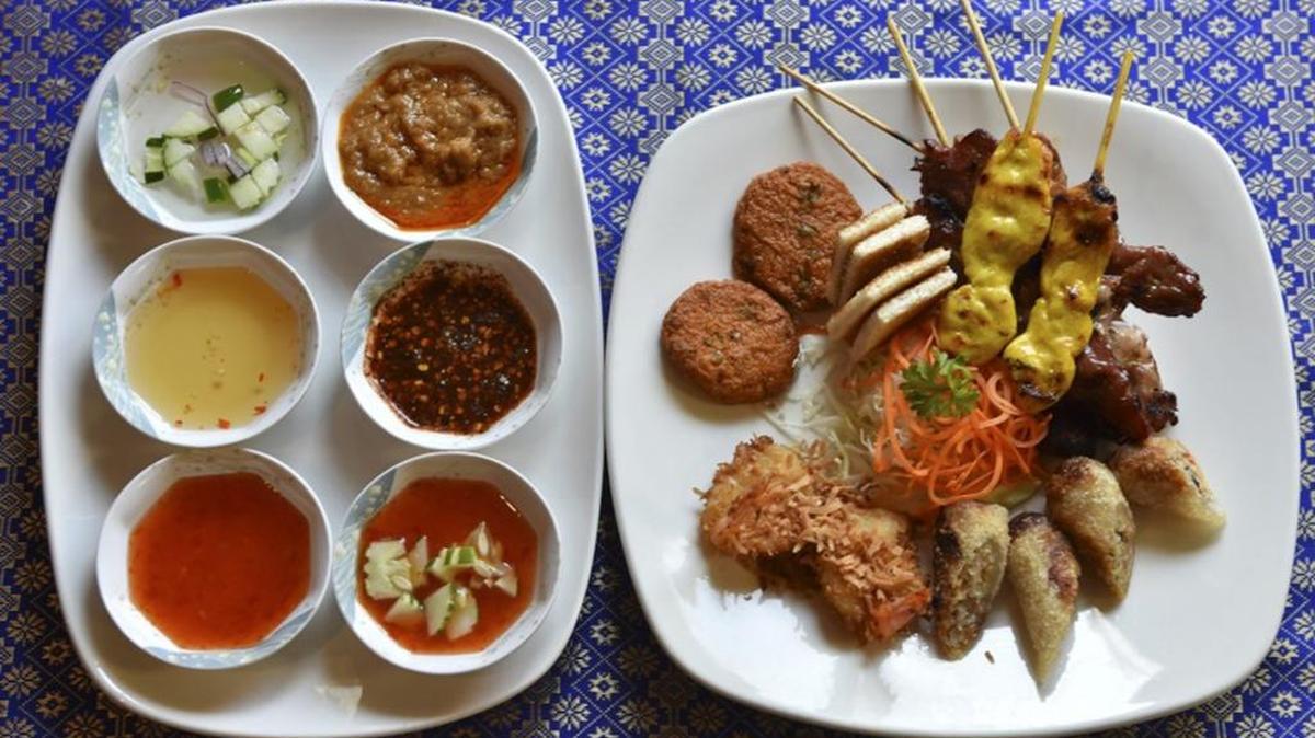 
Moo Yang, Gai Yang, Gai satay, Thai Taste crispy spring rolls, coconut shrimp, and fried fish cakes with spicy dipping sauces at a Thai restaurant; scientists theorize that we are drawn to hot spices because they are good for us. 
