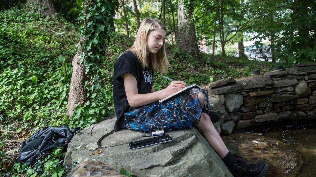 
Hunter Schafer sketches in her art journal Wednesday at University of North Carolina School of the Arts in Winston-Salem where she is a junior. Hunter transitioned from male to female as a teenager with help from doctors at Duke. A new center for gender-related disorders, located within the Duke Children’s Hospital & Health Center Child and Adolescent Gender Care facility, opened July 15.

