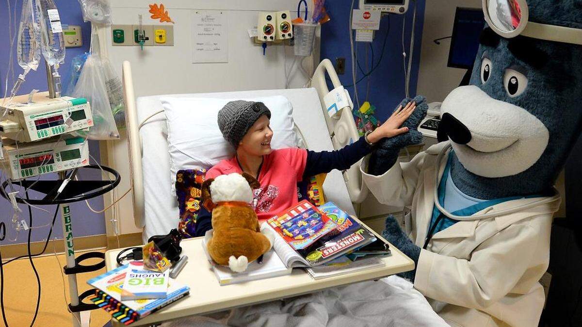 Elizabeth Brooks, 13, of Marshville, NC high fives Dr. Health E. Hound, the mascot for UnitedHealthcare after receiving a "Grins to Go" bag on Tuesday, October 27, 2015. UnitedHealthcare employees delivered the bags to children at Novant Health’s Hemby Children’s Hospital, a part of Novant Health Presbyterian Medical Center in Charlotte. The bags, stuffed with toys and books, can be purchased online. Proceeds help pay for UnitedHealthcare Children’s Foundation medical grants that help children gain access to health-related services not covered, or not fully covered, by their parents’ commercial health insurance plans.