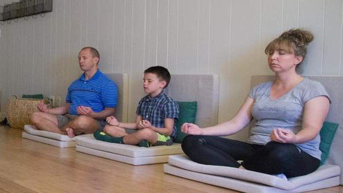 
From left Guru Ranjit, Joe Moore, Joshua Moore and Jill Moore sit and meditate during a session at Charlotte Meditation in Charlotte, NC on Saturday April 11. A growing number of children are taking part in meditation.
