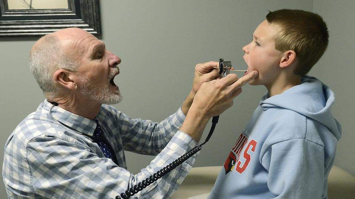 
Dr. Tom Humphries examines Nathan Swinney, 10, who has both asthma and environmental and food allergies. 
