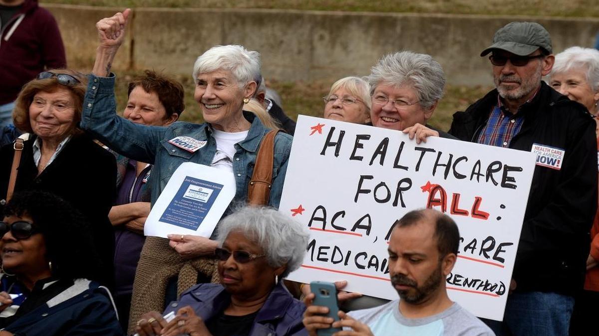 Terry Soffer, left, and Sue DuChanois show their support of the speakers opposing repeal of the Affordable Care Act at Sunday’s “Save Our Health Care” rally at Marshall Park.