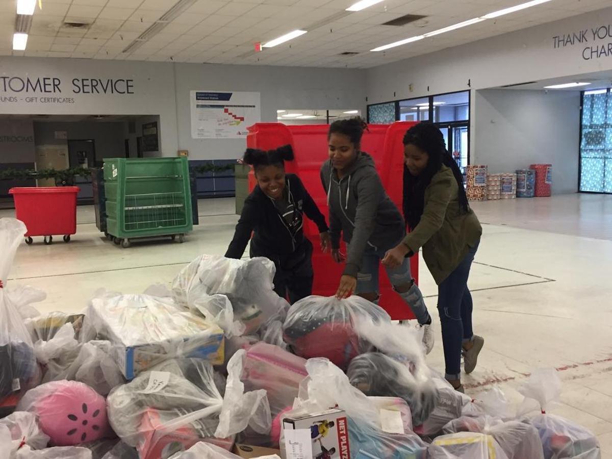 Jiani Bryant, left, Tamia Dandridge and Madison Robinson unload bags of toys after pulling them off a truck at the Salvation Army Christmas Bureau. The teens were volunteering as part of the Butler High School Black Student Union.