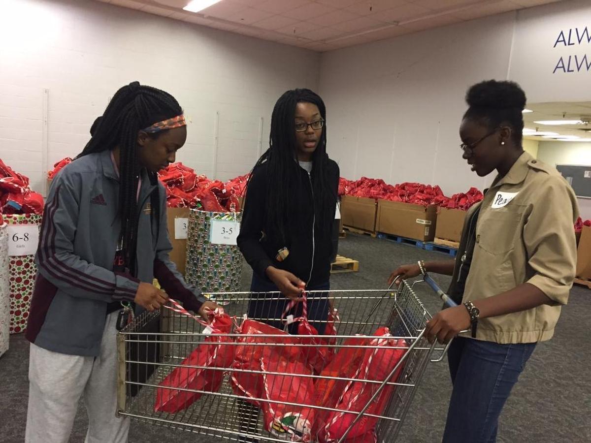 Camille Harvell, left, Abby Mobombo and Peace Olaleye of the Butler High School Black Student Union tie mesh stockings closed during an afternoon volunteering at the Salvation Army Christmas Bureau.