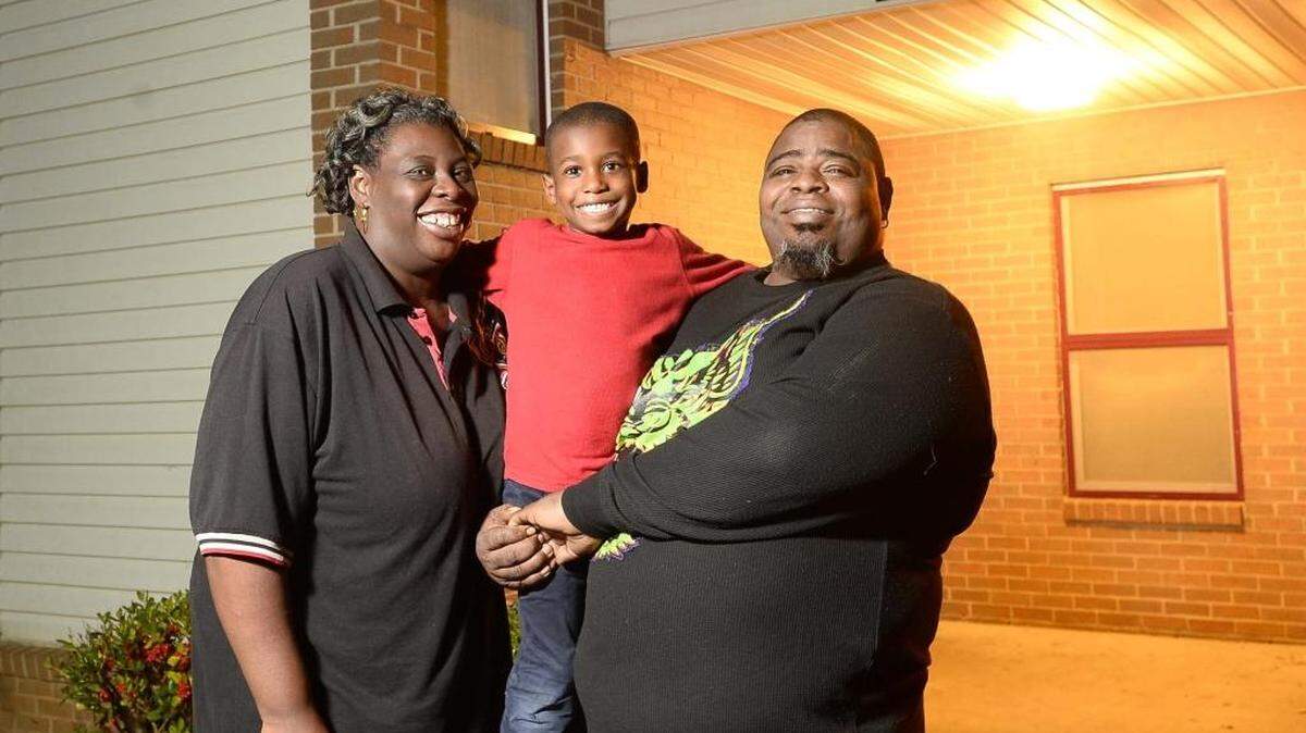 From left, Tasha Powell, Tyler Dean 7, with his father Michael Nutall at Tasha Powell's home in Charlotte. Tasha Powell is letting Michael Nutall and his 7-year-old son Tyler Dean live with her.