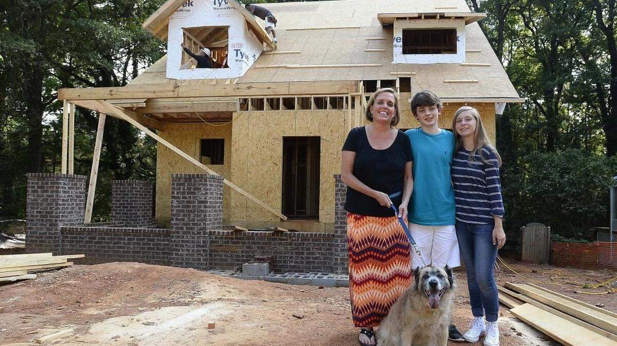 
 From left Mary Elizabeth DeAngelis with her children Vincent Williams 14, Allison Williams 12, and the family dog Aurora at their home under construction. DeAngelis and her husband decided to tear down their old home in the Chantilly neighborhood and build a new one in its place – a popular trend in areas close to uptown.
