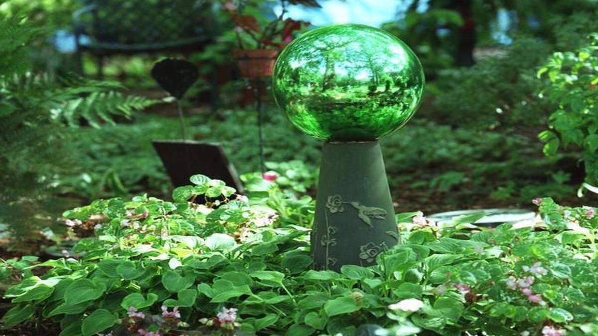 
This green gazing ball brightens a shady area when it’s hit by dappled sunlight. 

