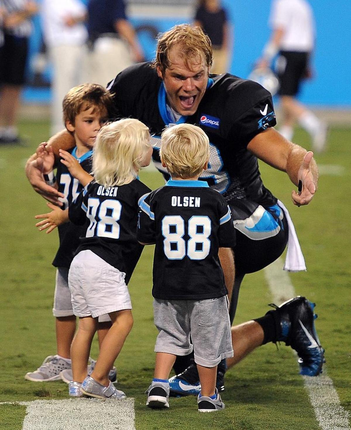 Carolina Panthers tight end Greg Olsen, right, greets son Tate, left, daughter Talbot, center and son TJ (right) in 2015. TJ, now 8, underwent a heart transplant in June.