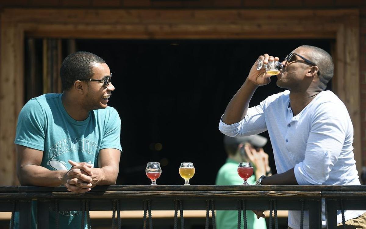 Charlotte’s breweries are built for making friends. Chad Barnes (left) and Montell Watson spend some time at Legion Brewing drinking Juicy Jay IPA and Wooden Robot combination beer.