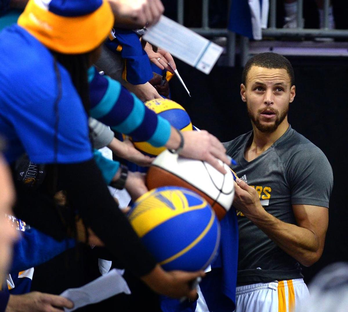 Golden State Warriors guard Steph Curry stops to sign autographs at the Spectrum Center.