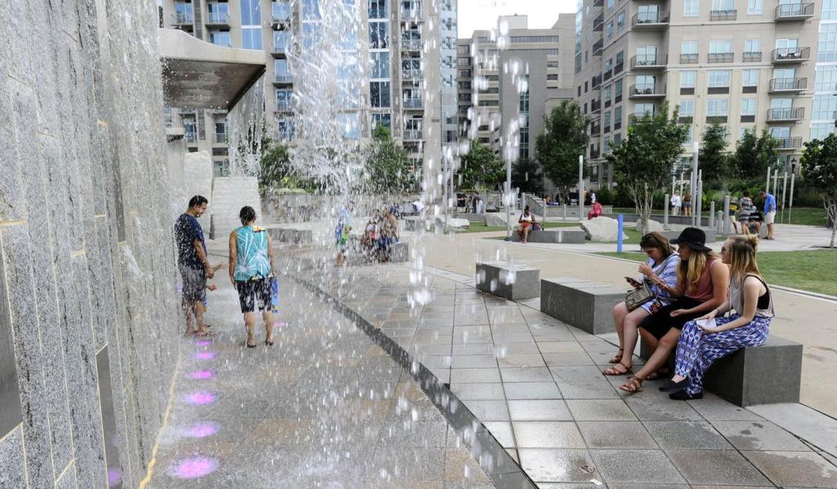 People play in the waterfall and sit in the shade at Romare Bearden Park. Charlotte could see its hottest days of 2020 on Sunday and Monday, July 19 and 20, with an expected high of 96 both days, according to the National Weather Service.