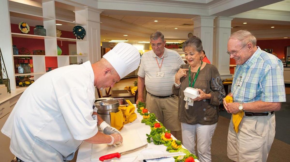 Chester Reeves, from left, Jenky Brooks and Glenn Monteith watch chef Joseph Unrue make his OSG (Oh So Good) chicken salad wrap at Aldersgate.