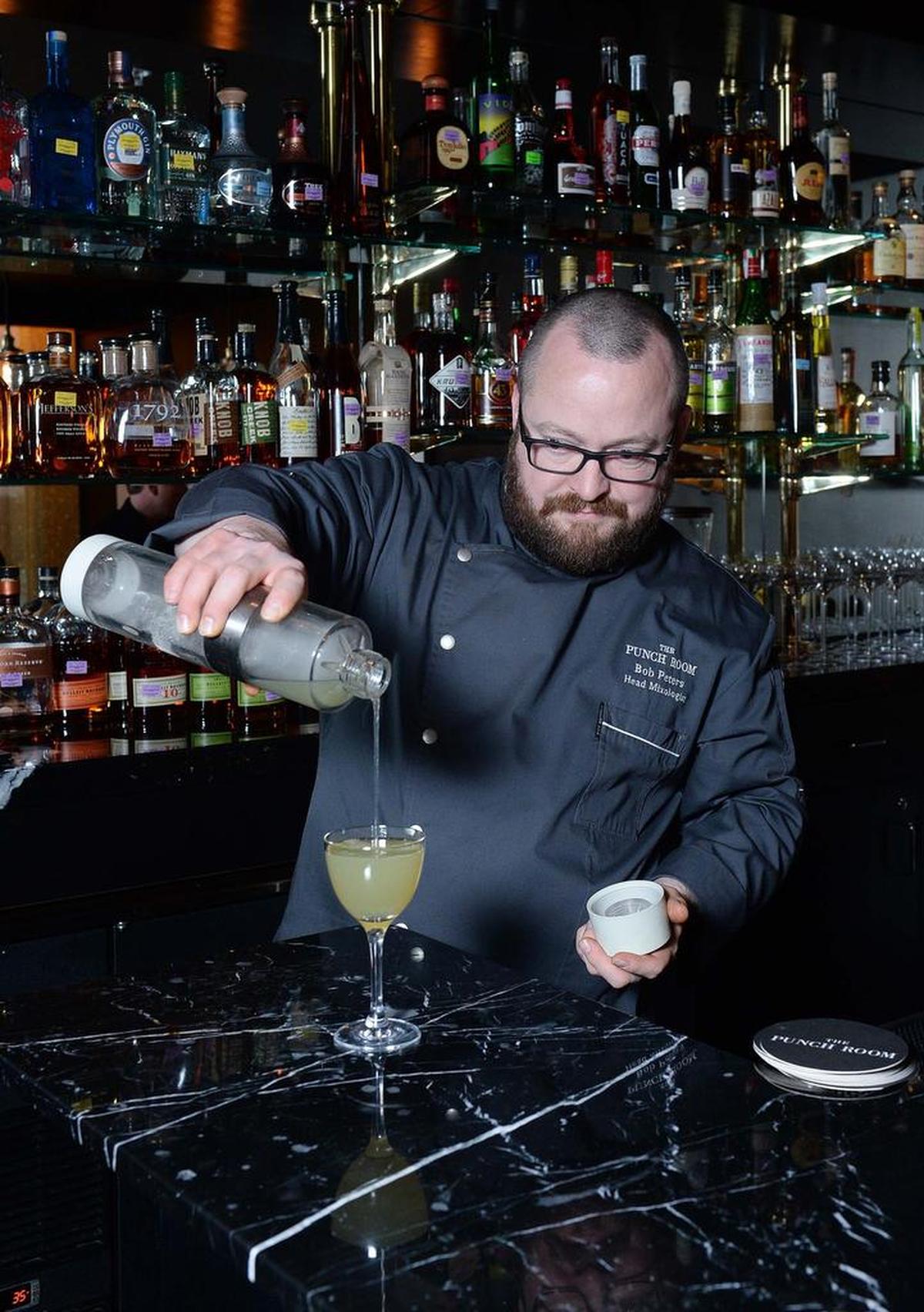 Bob Peters, head mixologist at the Ritz-Carlton Charlotte’s The Punch Room, pours “The Last Word” – a drink made with Cardinal barrel rested gin.