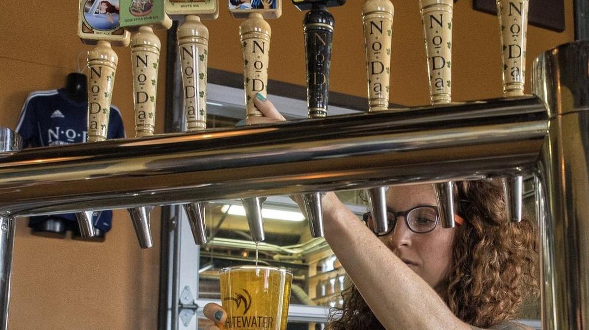 
Liz Eagle pours a beer in the taproom at NoDa Brewing.
