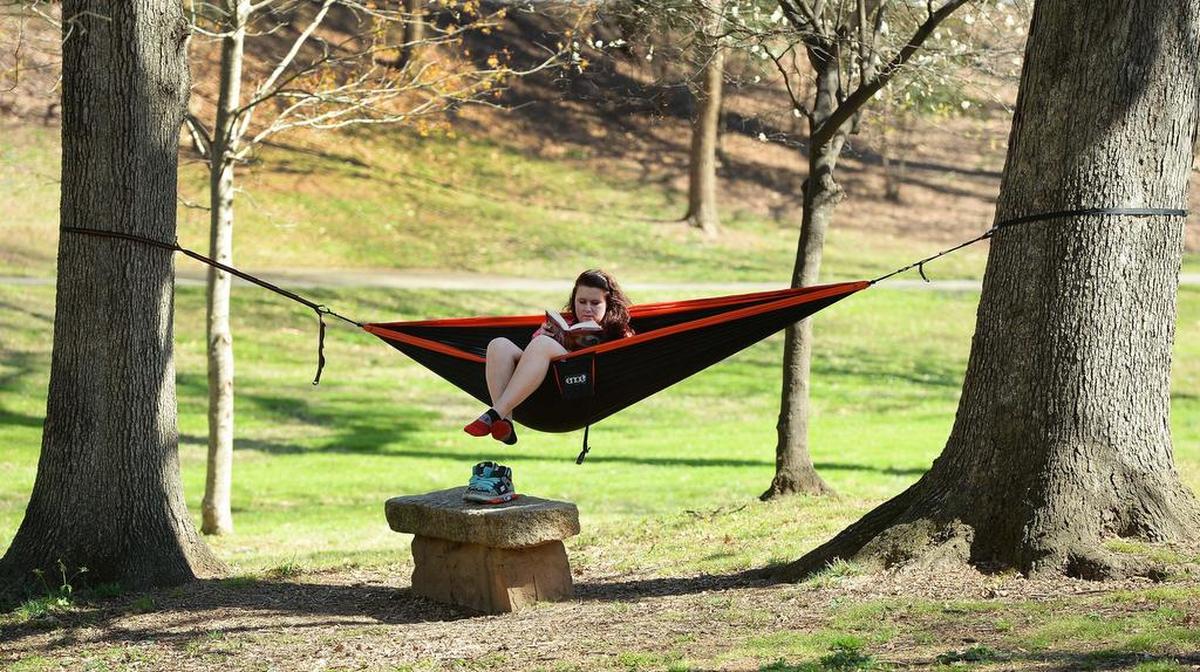 Analasah Hooper of Charlotte reads in a hammock at Independence Park.