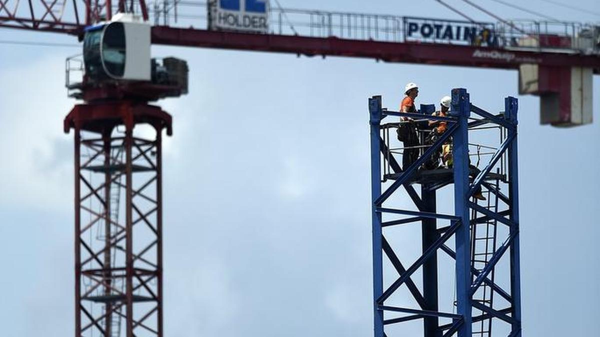 Iron workers construct a crane above Crescent Stonewall Station in uptown Charlotte in August 2016.