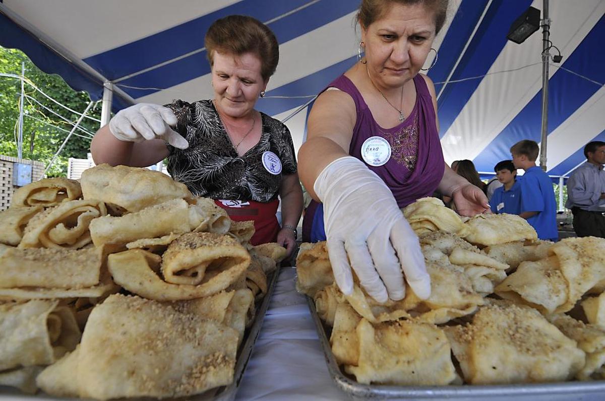 Eleni Bisbikis (left) and Anna Sohoritis stack fresh greek pastry “diples” on the tray during the lunch hour rush at the annual Yiasou Greek Festival in 2011.