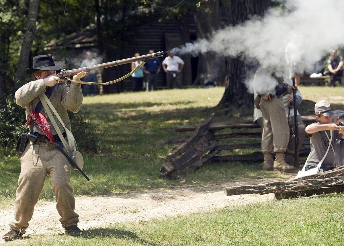 1st Sergeant Matthew Gamble, 15, fires a musket as the Confederates defend “Bloody Lane” during the last day of a Civil War camp at Historic Latta Plantation in Huntersville.