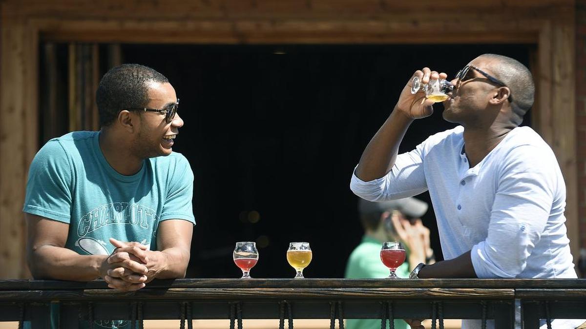 Charlotte’s breweries are built for making friends. Chad Barnes (left) and Montell Watson spend some time at Legion Brewing drinking Juicy Jay IPA and Wooden Robot combination beer.