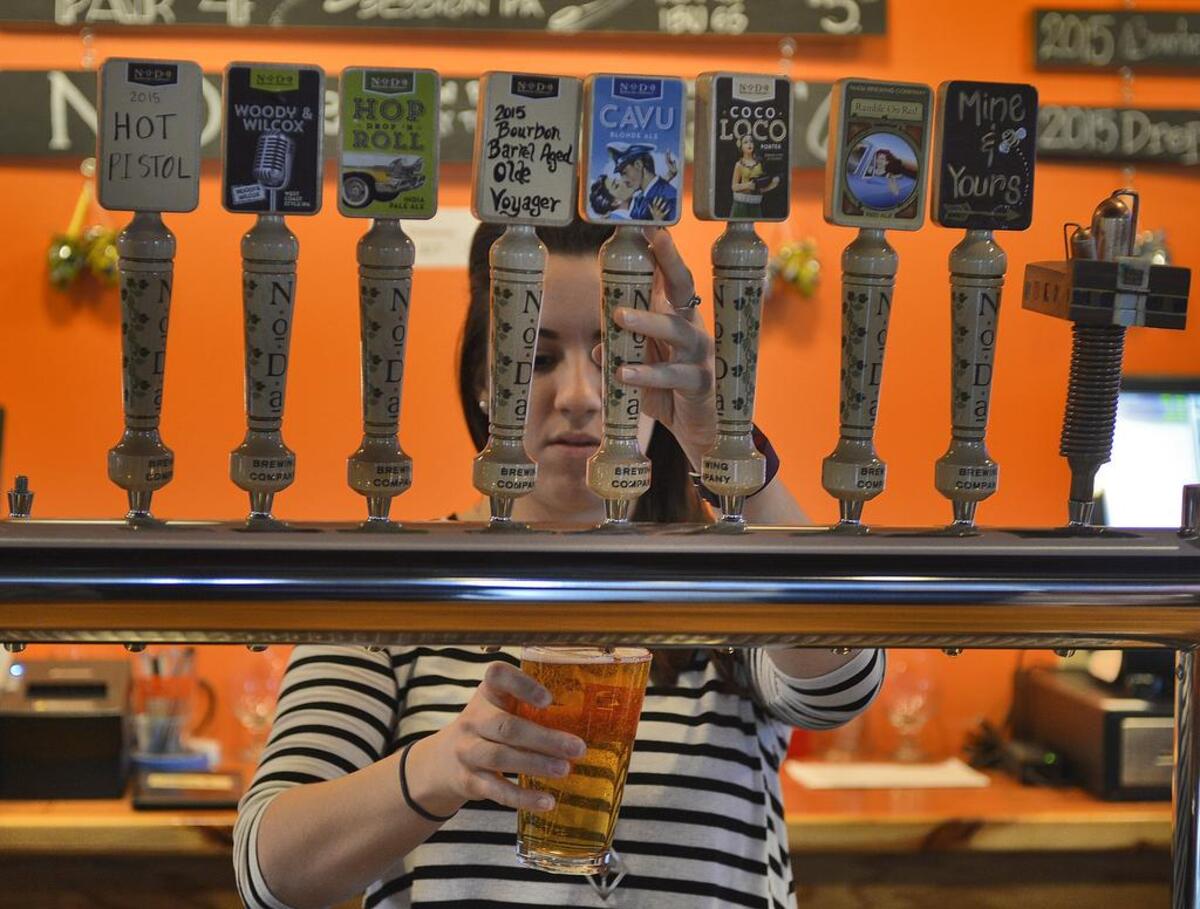 Bartender Caitlyn Higgins pours a customer's beer at NoDa Brewing in North End.