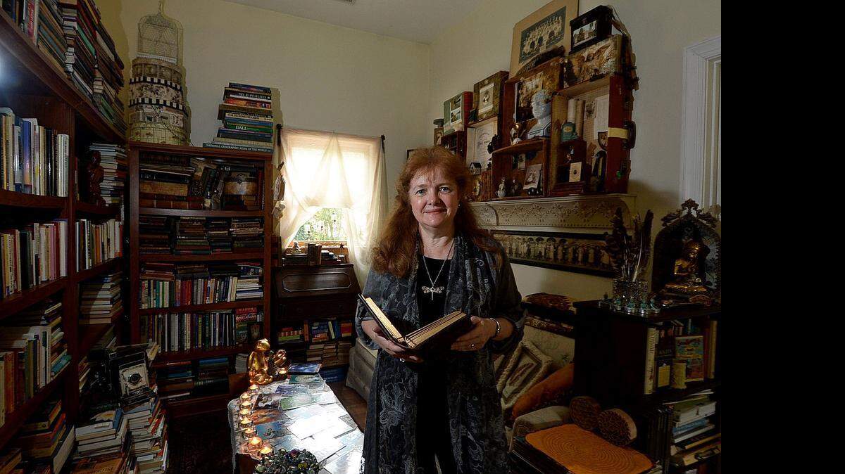 
Catherine Anderson with one of her journals in the portion of her studio built onto her home which she uses as a library, meditation and reading nook. She discovered all her experiences – the questionable career choices, the burnout, the ennui – combined to set her on a new, happier path. “When you take steps toward what you want, the rest of it meets you halfway,” she said.


