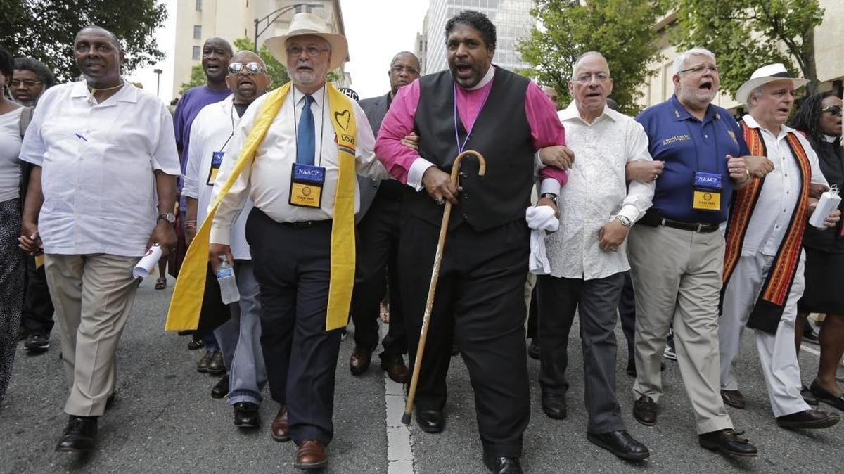 Rev. William Barber, center, led a 2015 march in Winston-Salem at the start of a federal voting rights trial challenging a 2013 state law. Barber is now set to co-lead the upcoming Poor People’s Campaign: A National Call for Moral Revival.