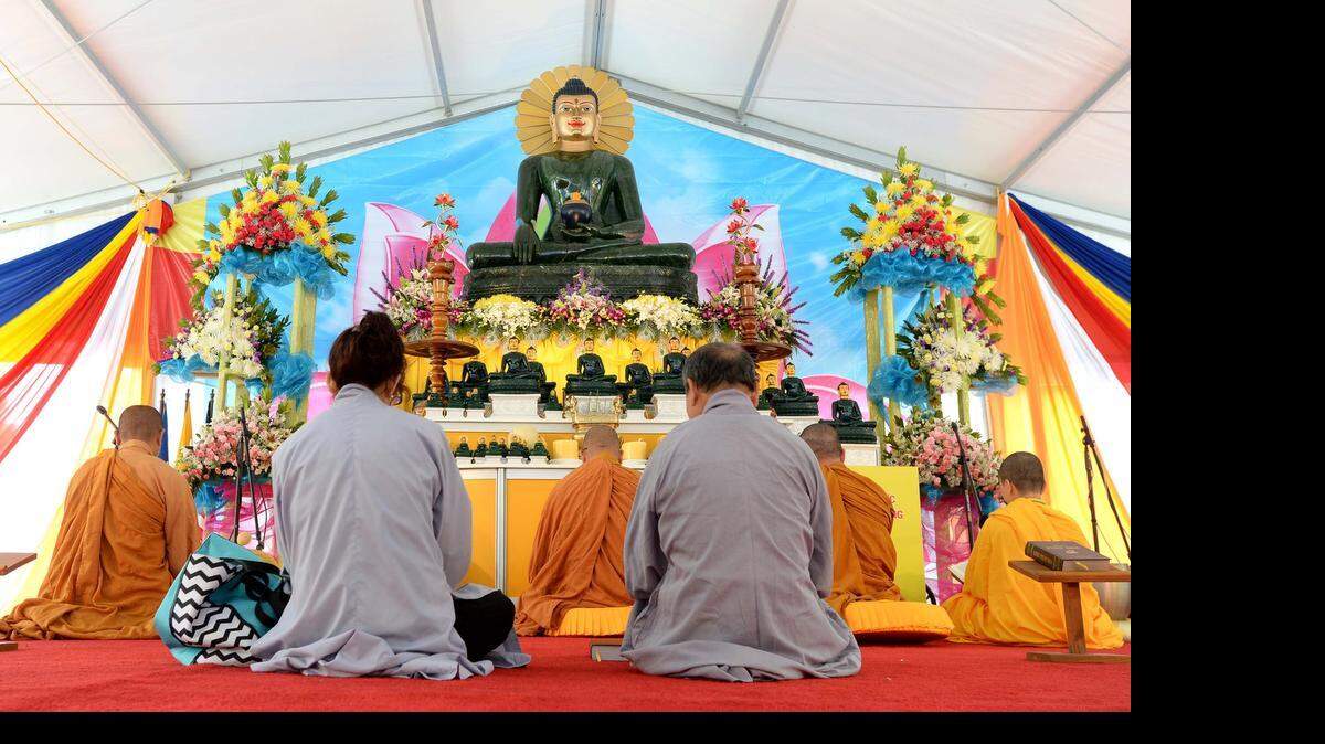 
Buddhist monks sit and pray at the altar of the Jade Buddha for Universal Peace during a morning prayer service. A traveling Buddha statue made of jade, standing nearly 8 feet tall, and weighing 4 tons on display at Minh Dang Quang monastery in Charlotte on May 10,2015, The monastery said it's expecting 10,000 visitors during the statue's run.
