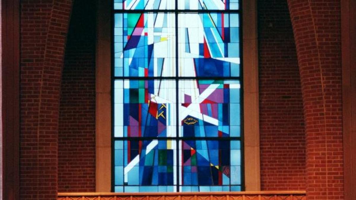 A stained glass window towers over the altar at St. John’s Episcopal Church.