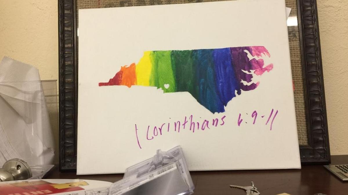 Written on the painting, which featured a rainbow-colored map of North Carolina, was 1 Corinthians 6: 9-11, which lists “wrongdoers” including “men who have sex with men” as well as idolaters, adulterers, thieves and others.