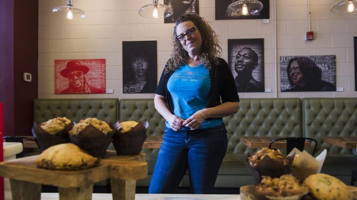 Faith Holmes, owner of Love 'n Faith Community Cafe, at her cafe in front of the exhibition "Given a Voice," a collection of work by students from the Duke Ellington School of the Arts Museum Studies Department in Washington.