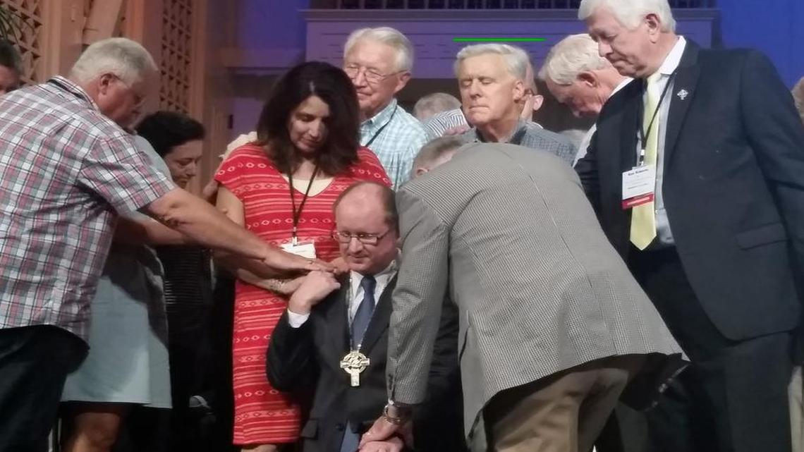 
Family, friends and former moderators lay hands on the Rev. Mike Moses, founding and lead pastor of Lake Forest Church in Huntersville, as the Assembly prays for the newly elected moderator.
