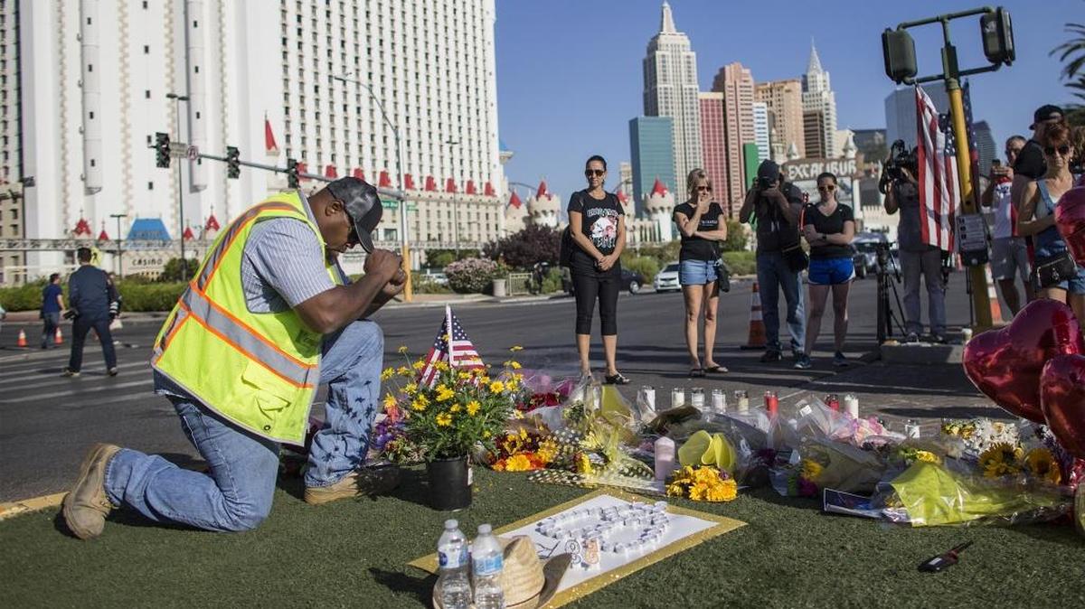 Contractor Robert Walker says a prayer after placing flowers and an American flag at the scene of a memorial for the victims of the mass shooting on Las Vegas Boulevard near the crime scene on Oct. 4, 2017 in Las Vegas.