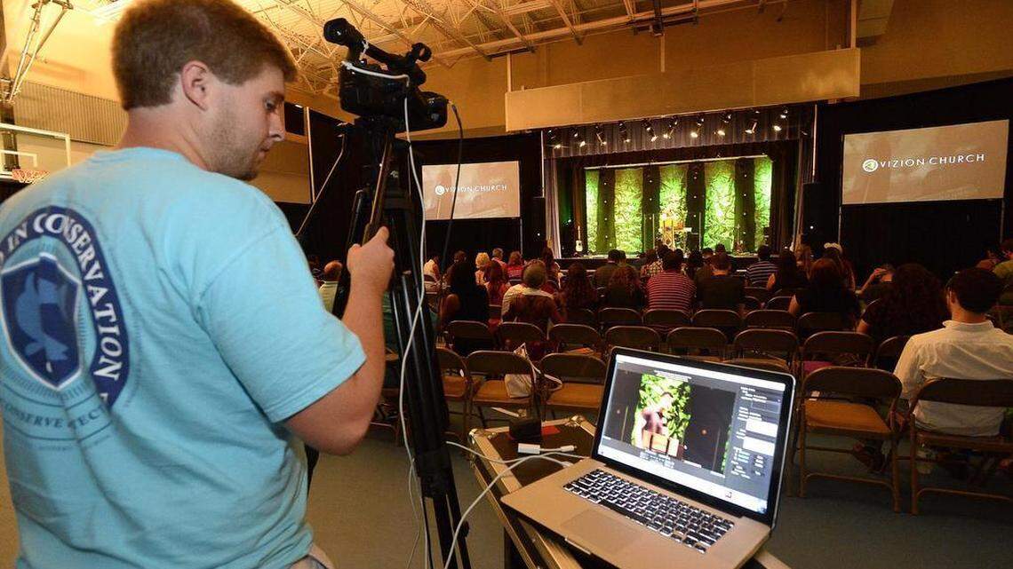 
Devan Alt records video during Vizion Church’s worship service Vizion Church publishes videos and audio podcasts of their sermons. 

