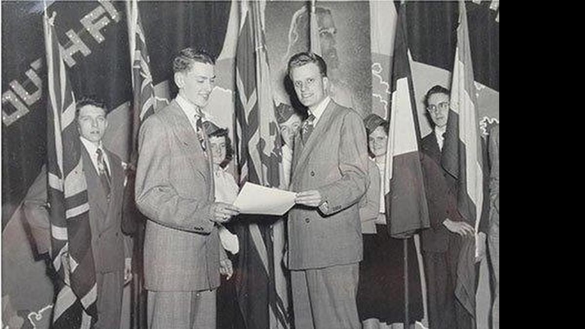 
In January 1949, Billy Graham (right) presents the charter for a local Youth for Christ organization to 17-year-old Leighton Ford in Chatham, Ontario.
